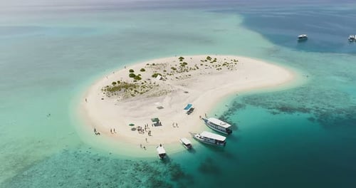 Aerial Footage of Small Sandy Island with People Resting, Walking and Swimming. Boat Cruise With Go