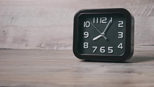 The Pointer Clock of Square Shape on Wooden Table Shows Time 8 Hours