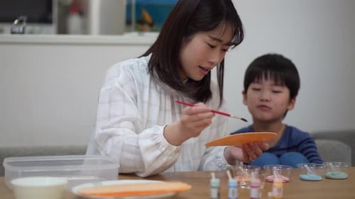 Caring Woman Painting Crafts with Child