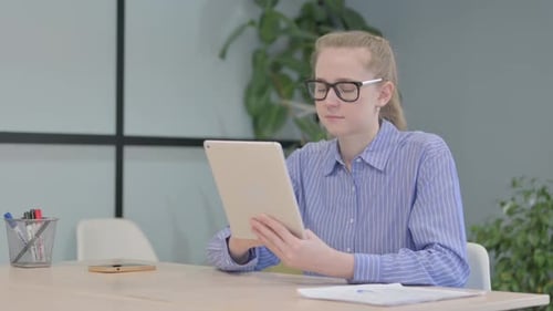 Woman Uses Tablet at Office Desk