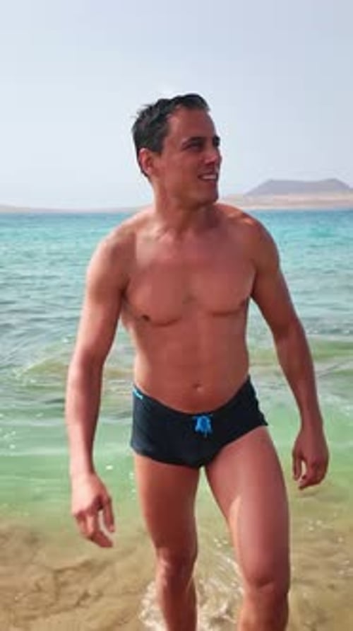 Muscular Man Walking Out of the Sea on Risco Beach