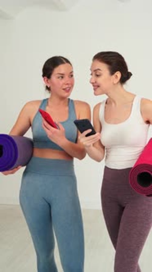 Women in Sportswear Chatting with Phones and Yoga Mats