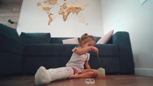 Girl with Cast Paints on Floor at Home