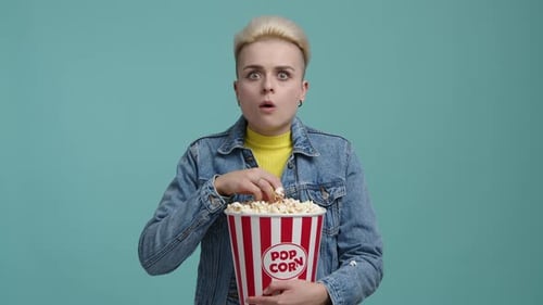 Woman Eating Popcorn with a Shocked Expression