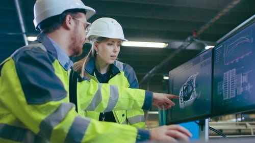 Inside Factory Male Mechanical Engineer and Female Chief Engineer Work Together on the Personal Com