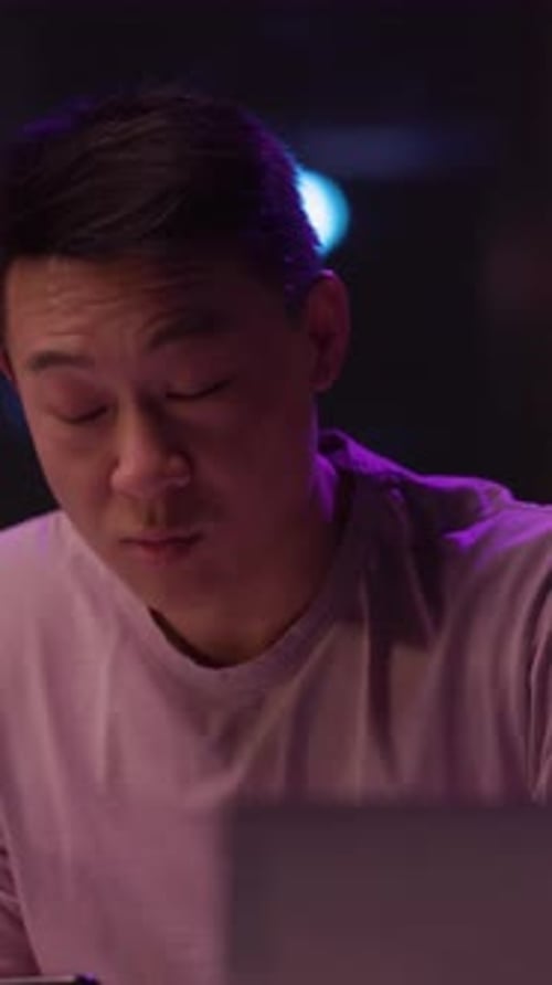 Podcaster Speaks to His Audience in Darkly Lit Room