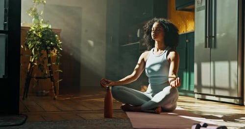 Woman Meditating at Home in Bright Sunlight