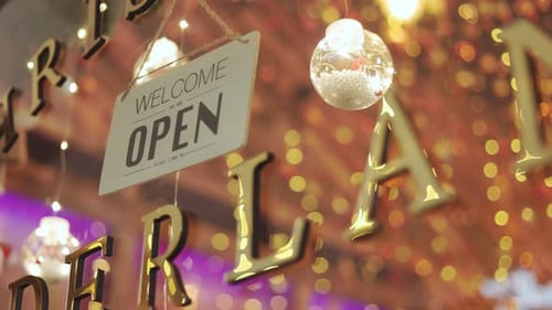 The woman shop owner flipping sign open to closed.