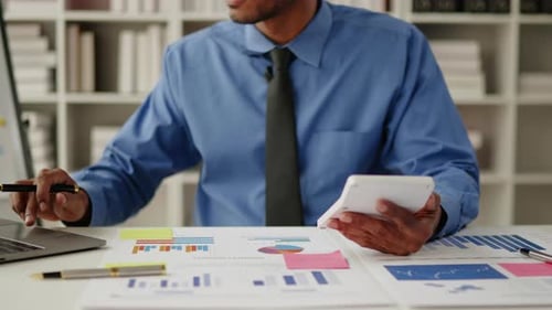 Nahaufnahme von Händen arbeiten und brainstormen an Papierkram zu den Themen Wirtschaft, Finanzen und Marketing.