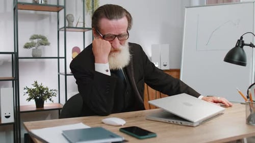 Senior Adult Frustrated with Laptop at Desk