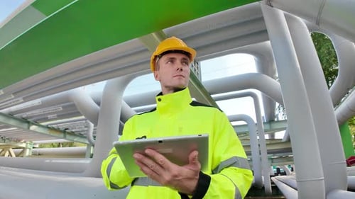 Un travailleur examine l'infrastructure du pipeline pendant la journée dans une installation extérieure