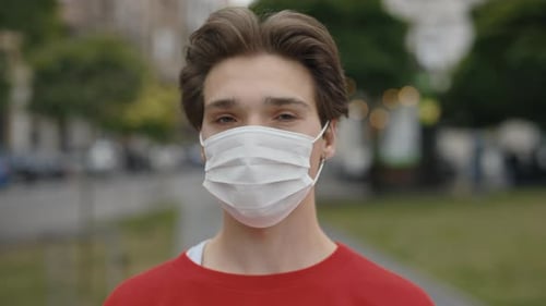 Serious Male Portrait Wearing Medical White Mask Outdoors with City Background Caucasian Man Guy