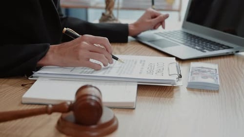 Legal Professional Working at Desk With Gavel