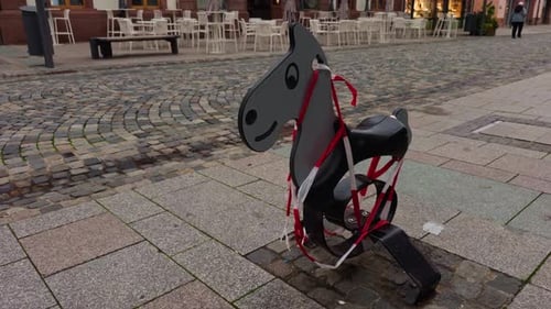 A Playful Horse Sculpture Gracefully Positioned in an Urban Setting Accompanied By a Charming