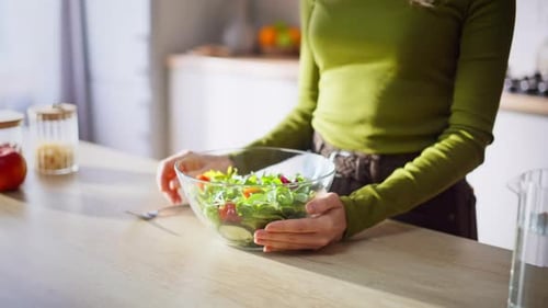 Smiling Woman Mixing a Fresh Salad in Kitchen