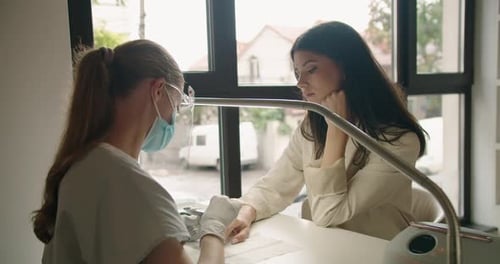 Attentive Nail Technician Giving a Manicure in Salon