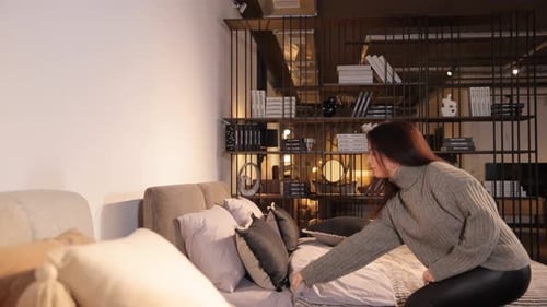 Woman Making Up Bed in Modern Bedroom