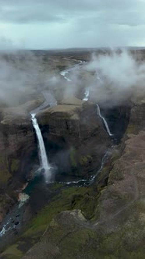 Spectacular Aerial View of Waterfall Flowing Through Rugged Landscape