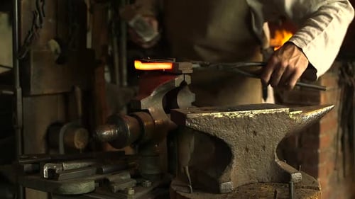 Blacksmith Working on Metal With Hammer and Anvil