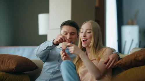 Happy Couple Celebrating New Home on Sofa