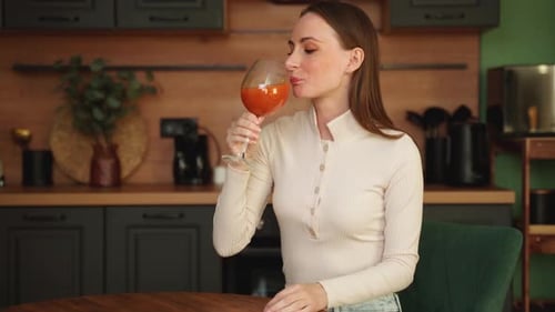 Woman Drinking Juice in Kitchen