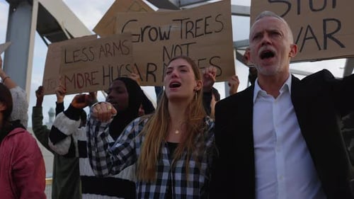 People Demonstrating and Shouting with Raised Fists