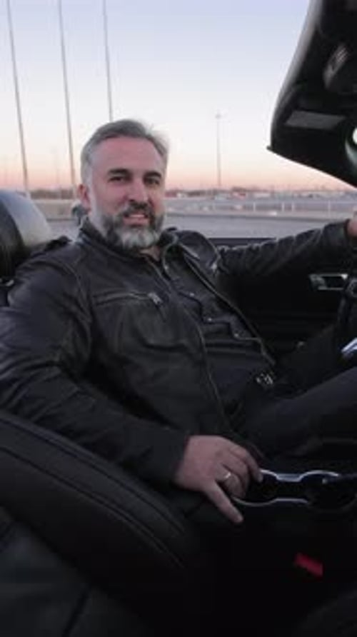 A Man Sits in a Luxurious Convertible Mature Man with a Content Expression Driving a Convertible Car