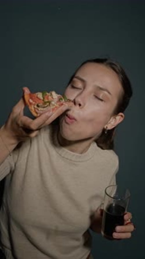 Young Woman Eats Pizza and Drinks Soda