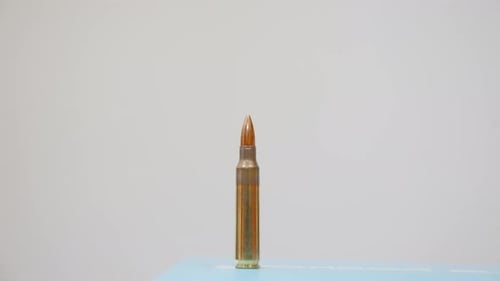 Hand Placing Bullets on Surface, Close Up