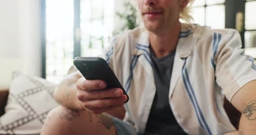 Man Sitting on Couch Using Mobile Phone Indoors