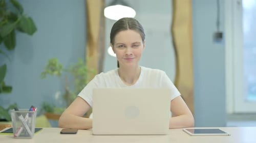 Woman Working on Laptop Gives Thumbs Up
