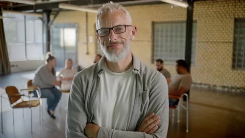 Mature Man Smiling with Meeting in Background