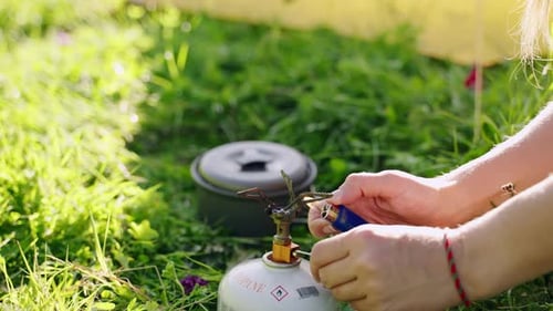 Woman Sets Up Portable Stove Outdoors for Cooking