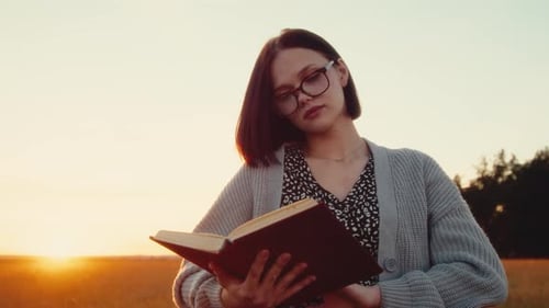 Young Woman Reading Book in Golden Field