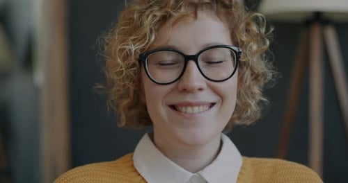Smiling Woman with Blonde Curls and Glasses