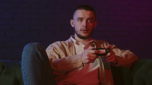 Man Playing Video Game on Couch at Night