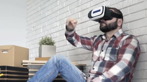 Jovem com óculos de realidade virtual configurando o projeto visual de um novo apartamento