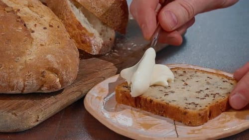Hands Spreading Creamy Spread on Bread Slice