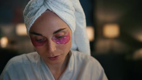Woman Wearing Eye Patches at Home at Night