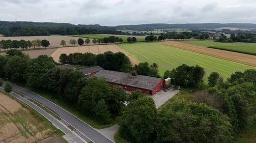 Traditional American farmstead building and barn in rural landscape. Cloudy summer day in Indiana. A