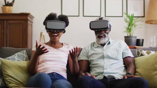 Couple Experiencing Virtual Reality Headsets on Couch