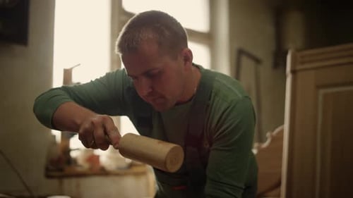 Closeup Wood Worker Using Tools in Carpentry Workshop. Portrait of Focused Handyman
