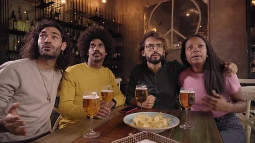 Friends Cheering while Watching at a Bar