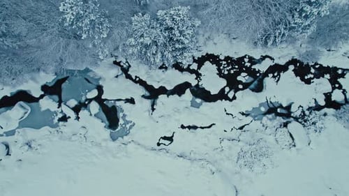 Aerial Drone Shot of Snow Covered River in Forest