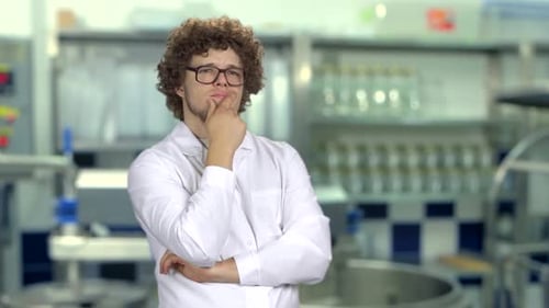 Man in Lab Coat Thinking in Laboratory Setting
