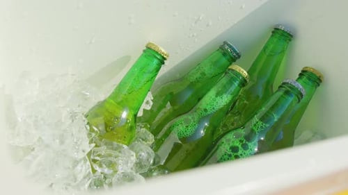 Nevera llena de hielo con cerveza