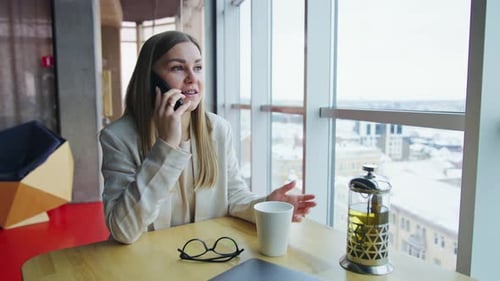 Business Woman Talking on Phone in Cafe