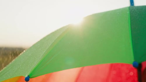 Raindrops Glisten on Colorful Umbrella Outdoors