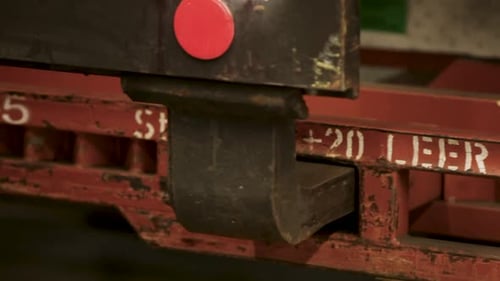 Close-up of a red train coupling mechanism with faded white text