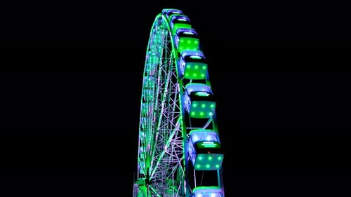 Großes, erstaunlich beleuchtetes, buntes, rotierendes Riesenrad im Hintergrund, dunkle Himmelsnacht. Kirmes. 4K.